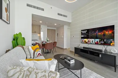 a living room with a couch and a tv at The Queens Tranquil Oasis 1BDR in Dubai