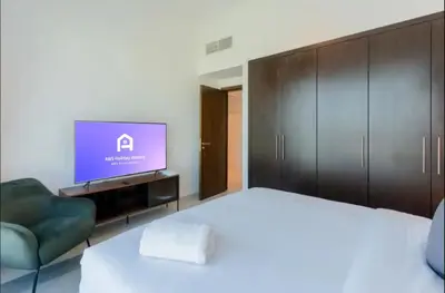 a bedroom with a bed and a flat screen tv at AWS Holiday Homes - Comfort and Marina Views in Dubai