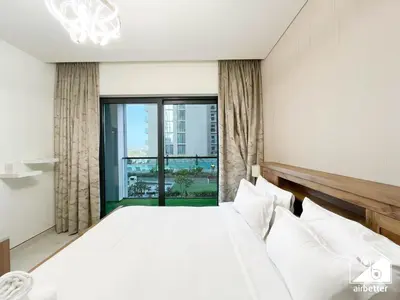 a bedroom with a large bed and a large window at Modern 2B Apartment with Pool Acess SOBHA CREEK in Dubai