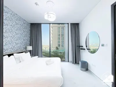 a white bedroom with a large bed and a mirror at Modern 2B Apartment with Pool Acess SOBHA CREEK in Dubai