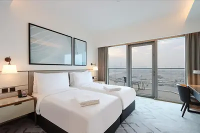 a hotel room with two beds and a large window at Livbnb - Premium 3BR with Burj Skyline View in Dubai