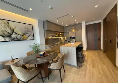 a kitchen and living room with a table and chairs at Bespoke Holiday Homes - Cozy 1BR Retreat in Haven Residences JVC in Dubai
