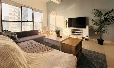 a living room with a couch and a tv at Golden Hour Stay Sea View in Marina Dubai in Dubai
