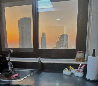 a kitchen sink and a window with a view of a city at Golden Hour Stay Sea View in Marina Dubai in Dubai