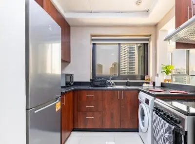 a kitchen with a stainless steel refrigerator and a dishwasher at Golden Hour Stay Sea View in Marina Dubai in Dubai
