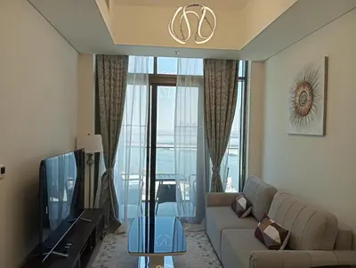 a living room with a couch and a tv at Bespoke Holiday Homes - 1BR Apartment with Creek View in Al Jaddaf in Dubai