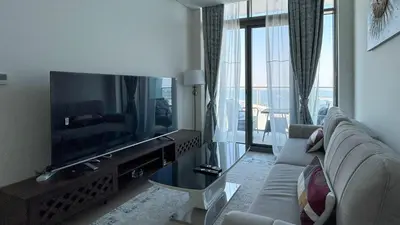 a living room with a couch and a large television at Bespoke Holiday Homes - 1BR Apartment with Creek View in Al Jaddaf in Dubai