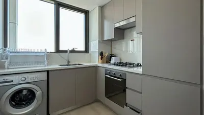 a kitchen with a washing machine and a washer at Bespoke Holiday Homes - 1BR Apartment with Creek View in Al Jaddaf in Dubai