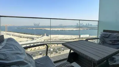 a balcony with a table and a view of the water at Bespoke Holiday Homes - 1BR Apartment with Creek View in Al Jaddaf in Dubai