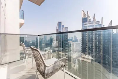 a balcony with chairs and a view of the city at Apartment Steps from Burj Khalifa, Dubai Mall & Metro, Act One Act Two Tower 1, Downtown Dubai By Deluxe Holiday Homes in Dubai