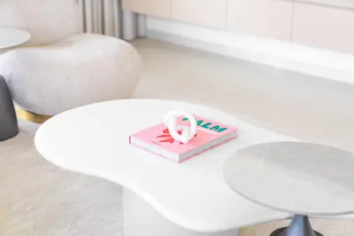 a white table with a pink box with a peace sign on it at Upscale 2-BR with Sea View - Grand Bleu by Elie Saab in Dubai