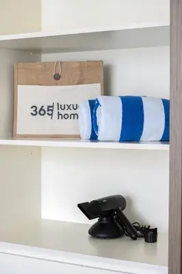 a shelf with blue and white towels on it at Upscale 2-BR with Sea View - Grand Bleu by Elie Saab in Dubai
