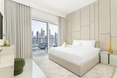 a bedroom with a white bed and a large window at Upscale 2-BR with Sea View - Grand Bleu by Elie Saab in Dubai