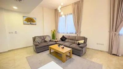 a living room with two couches and a coffee table at Joya Verde Residence - 1BHK Huge Apartment in Dubai