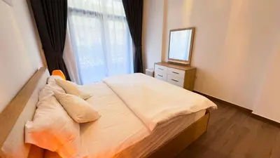 a bedroom with a bed with a mirror and a window at Joya Verde Residence - 1BHK Huge Apartment in Dubai