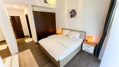 a bedroom with a large white bed with two lamps at Joya Verde Residence - 1BHK Huge Apartment in Dubai