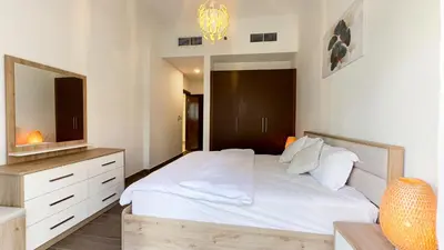 a bedroom with a white bed and a mirror at Joya Verde Residence - 1BHK Huge Apartment in Dubai