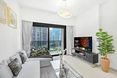 a living room with a couch and a tv at Majestic ActOne 1BR dowtown Dubai in Dubai