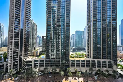 a city skyline with tall buildings and palm trees at Majestic ActOne 1BR dowtown Dubai in Dubai