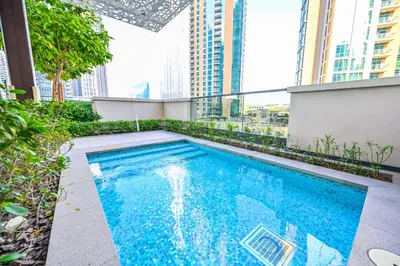 a swimming pool on top of a building with tall buildings at Majestic ActOne 1BR dowtown Dubai in Dubai