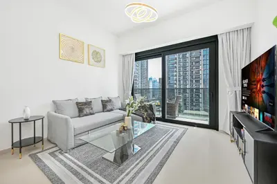 a living room with a couch and a large window at Majestic ActOne 1BR dowtown Dubai in Dubai