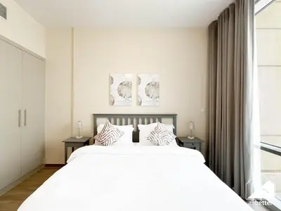 a bedroom with a large white bed and a window at Stunning 2-Bedroom Apartment with Canal Views in Dubai