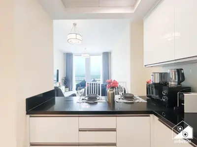 a kitchen with white cabinets and a black counter top at Wonderful 2B with Canal Views at Amna Tower in Dubai