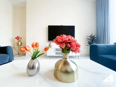 two vases with flowers on a table in a living room at Wonderful 2B with Canal Views at Amna Tower in Dubai