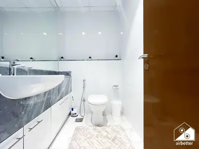 a white bathroom with a sink and a toilet at Wonderful 2B with Canal Views at Amna Tower in Dubai