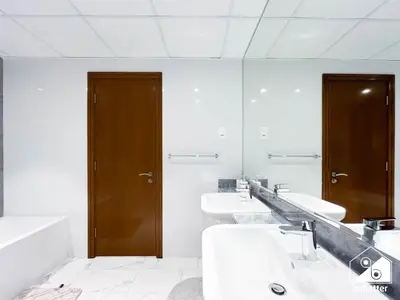 a bathroom with three sinks and a mirror at Wonderful 2B with Canal Views at Amna Tower in Dubai