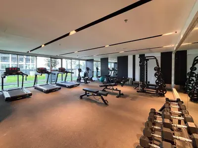 a gym with several treadmills and machines in a room at Frank Porter - Nobles Tower in Dubai