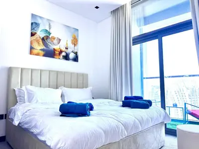 a bedroom with a large bed with blue pillows on it at 5 Star Apartment Dubai Burj KhalifaView in Dubai