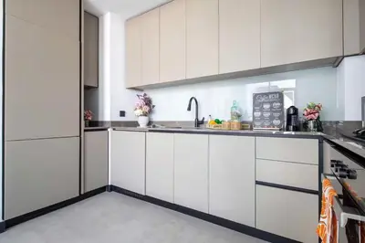 a white kitchen with white cabinets and a sink at 5 Star Apartment Dubai Burj KhalifaView in Dubai