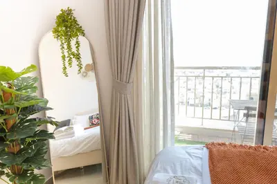 a mirror in a bedroom next to a window at Serene studio apartment with Burj Khalifa view in Jumairah Village Circle JVC in Dubai
