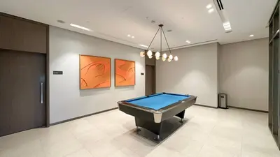 a pool table in a room with paintings on the wall at 2BR Next to Burj Khalifa& Dubai Mall in Grande Residence in Dubai