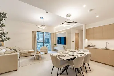 a kitchen and living room with a table and chairs at 2BR Next to Burj Khalifa& Dubai Mall in Grande Residence in Dubai