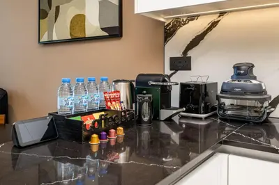 a kitchen counter with a coffee maker and water bottles at Trillionaire Bayhouse - Chic 1BR with Views, Pool and Gym in Dubai