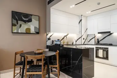 a kitchen with a table and chairs in a kitchen at Trillionaire Bayhouse - Chic 1BR with Views, Pool and Gym in Dubai