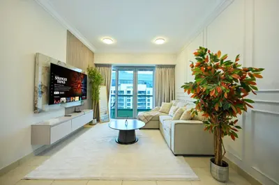 a living room with a couch and a tv at Stylish 1BR in 8 Boulevard Walk in Dubai