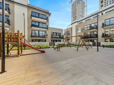 a playground with a swing set in front of a building at Brand New Luxury 2Bedroom in JVC with 5 Star Amenities in Dubai