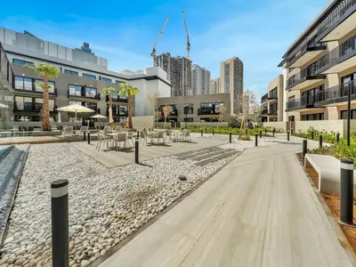 a courtyard with tables and chairs in a building at Brand New Luxury 2Bedroom in JVC with 5 Star Amenities in Dubai