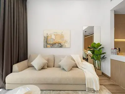 a living room with a couch and a painting on the wall at Brand New Luxury 2Bedroom in JVC with 5 Star Amenities in Dubai