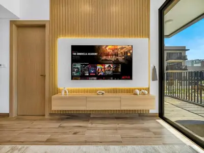 a living room with a tv on a wall at Brand New Luxury 2Bedroom in JVC with 5 Star Amenities in Dubai