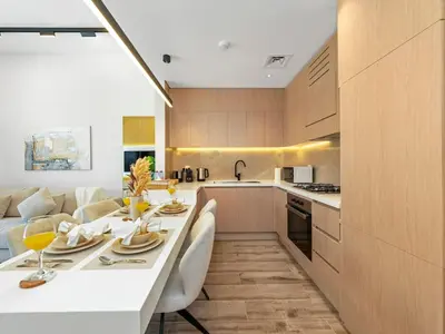 a kitchen and living room with a table and chairs at Brand New Luxury 2Bedroom in JVC with 5 Star Amenities in Dubai