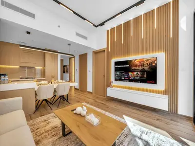 a living room with a tv on a wall at Brand New Luxurious 2 Bed in JVC with Padel Court in Dubai
