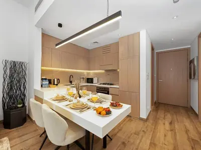 a kitchen with a white table with food on it at Brand New Luxurious 2 Bed in JVC with Padel Court in Dubai