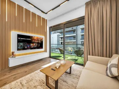 a living room with a couch and a tv at Brand New Luxurious 2 Bed in JVC with Padel Court in Dubai