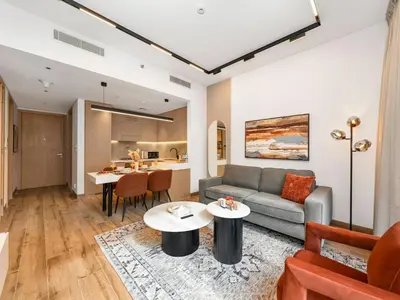 a living room with a couch and a table at Brand New Luxury 2 Bedroom with Padel Gym Pool Cinema in Dubai