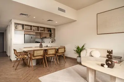 a kitchen and living room with a table and chairs at Seraya Residence 3 - 4BDR - Burj Views - Amenities and Concierge in Dubai