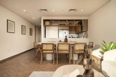 a kitchen and living room with a table and chairs at Seraya Residence 3 - 4BDR - Burj Views - Amenities and Concierge in Dubai